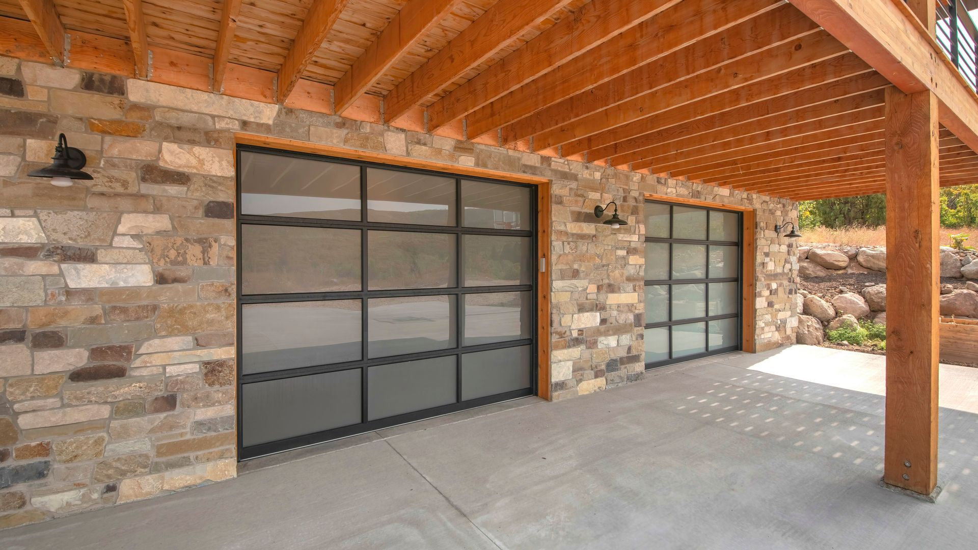 A stone building with a wooden roof and a large garage door.