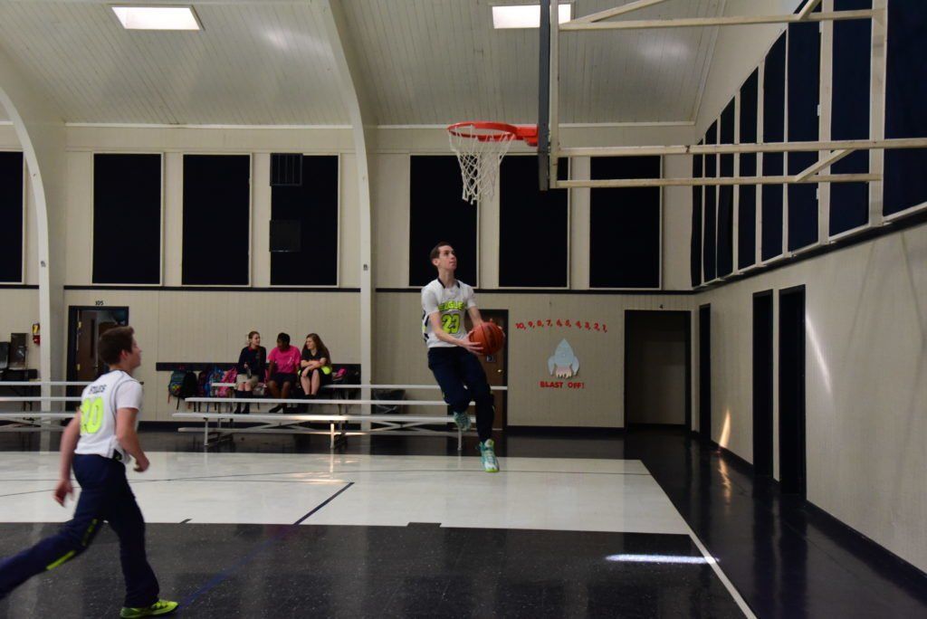 A man is jumping in the air to dunk a basketball