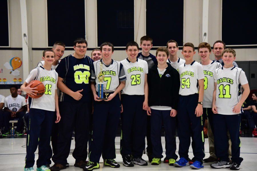 A group of young men are posing for a picture with a basketball.