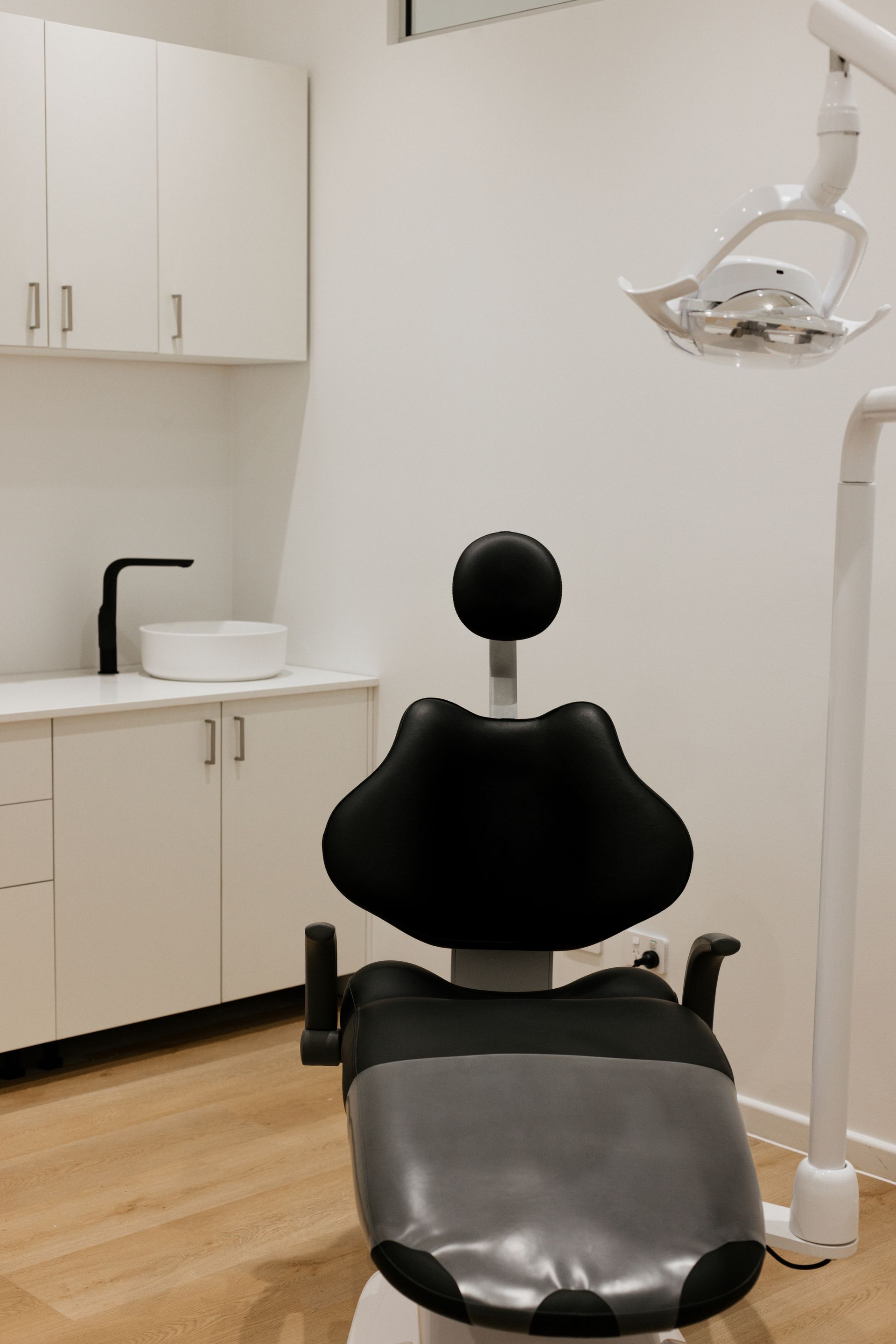A Person Is Holding A Denture With Screws On It — Harvey Smiles Denture Clinic In Burleigh Heads, QLD