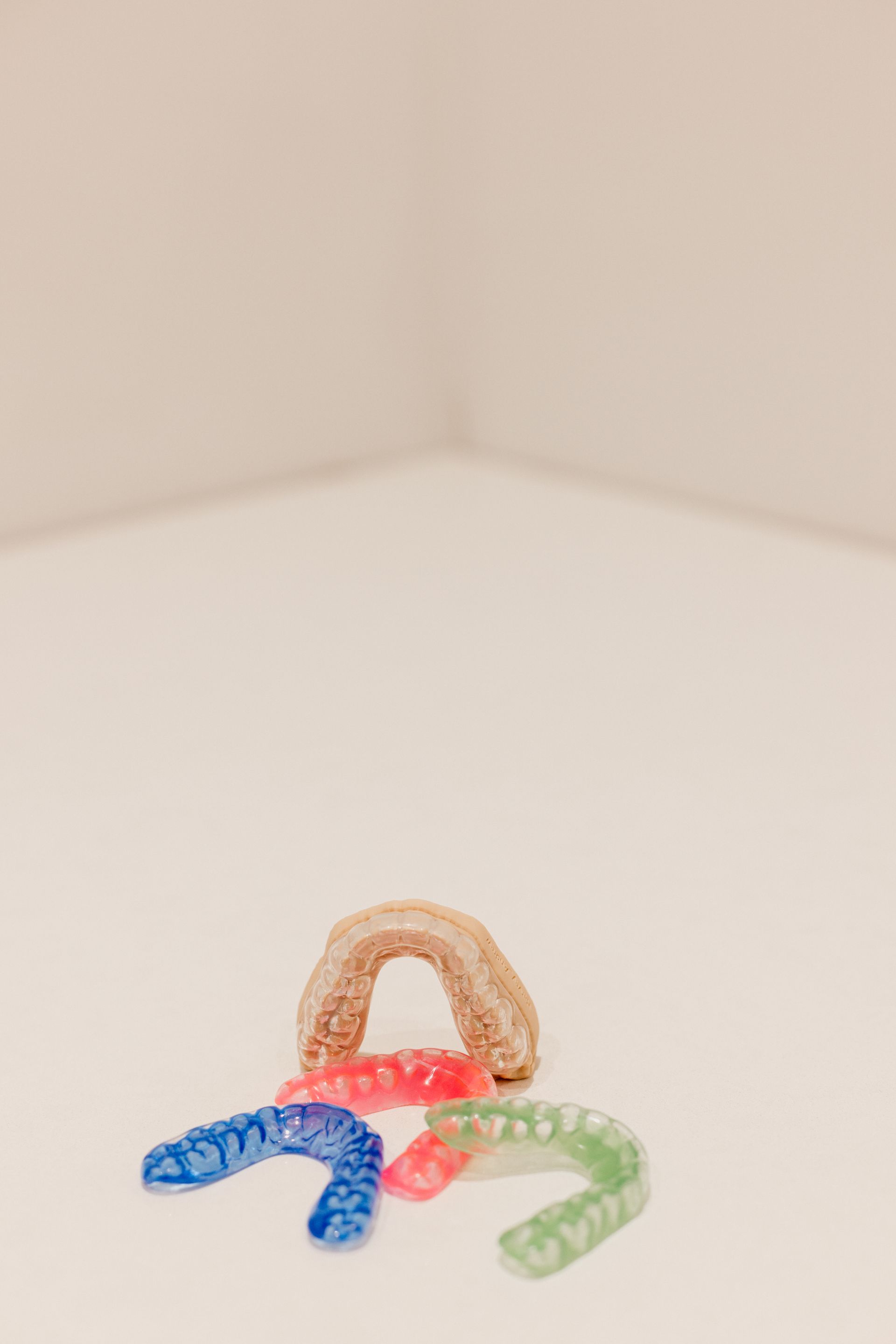 A Denture Is Sitting On A Wooden Table — Harvey Smiles Denture Clinic In Burleigh Heads, QLD