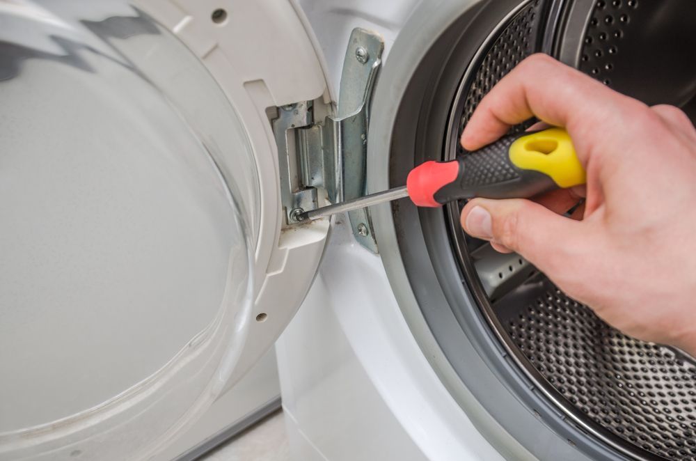 Hand Uses a Yellow and Red Screwdriver — Eurocoast Appliance Service In Tuggerah, NSW