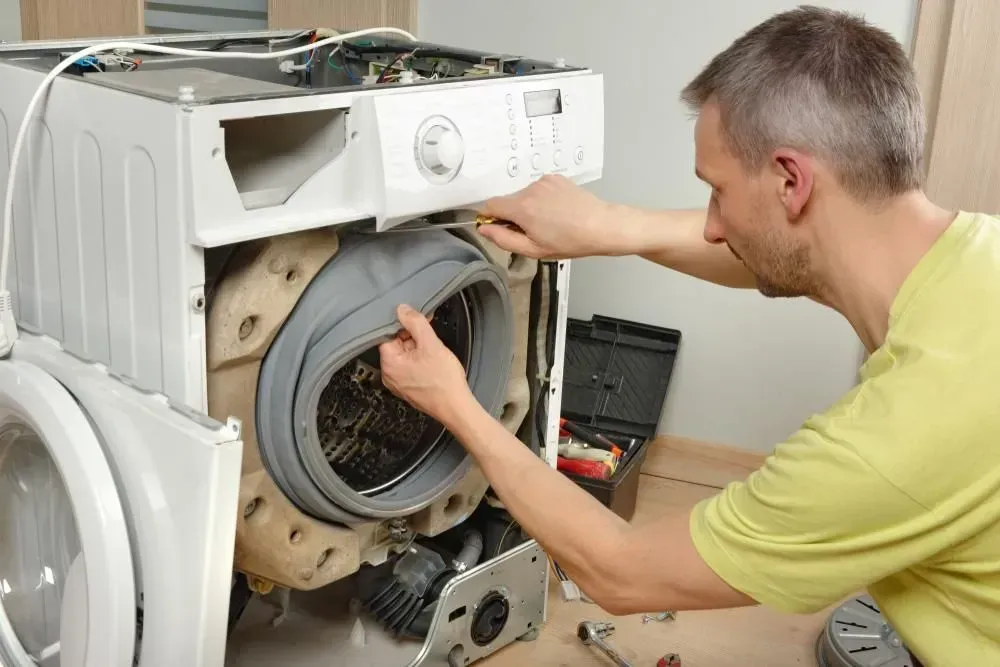 Person Repairs the Washing Machine — Eurocoast Appliance Service In Woy Woy, NSW
