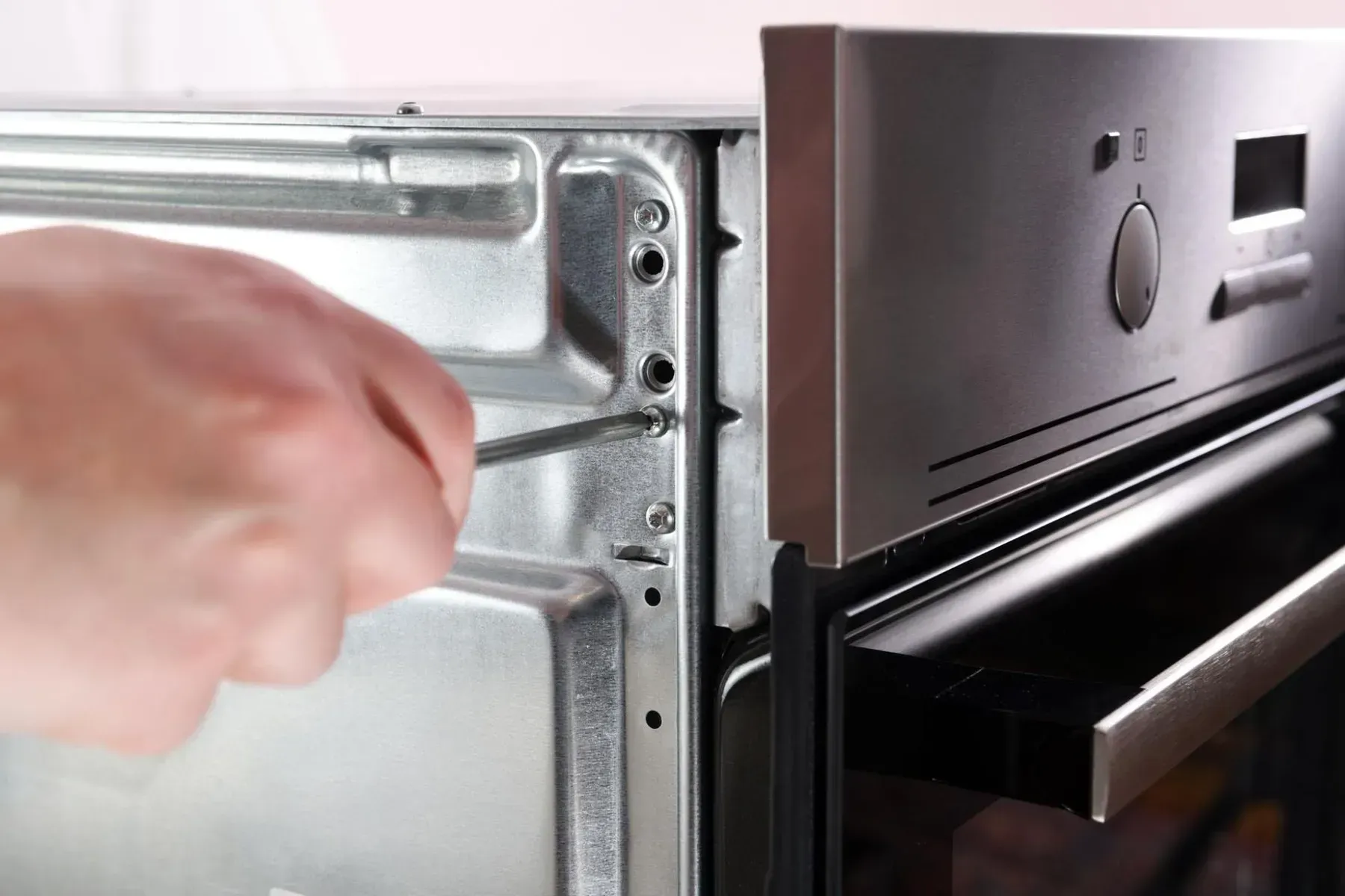 Person Uses a Screwdriver to Tighten a Screw — Eurocoast Appliance Service In Gosford, NSW