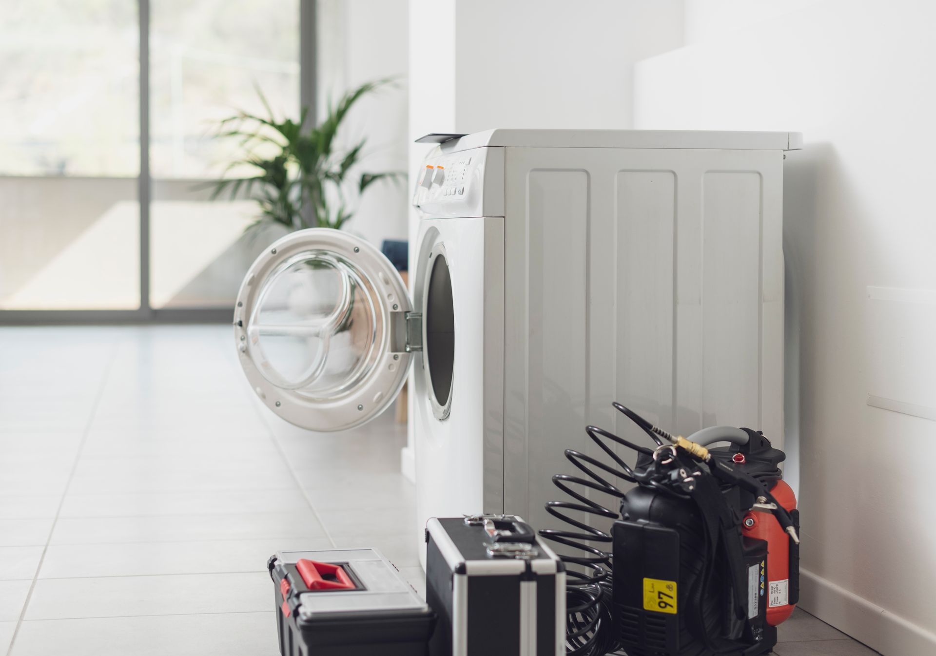 A White Washing Machine With an Open Door Sits on a Tiled Floor — Eurocoast Appliance Service In Woy Woy, NSW