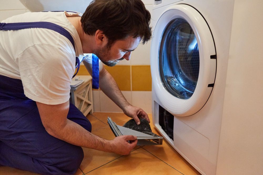Technician Clean the Lint Filter of a White Clothes Dryer — Eurocoast Appliance Service In Gosford, NSW