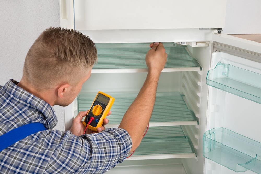 Person in a Plaid Shirt and Blue Work Straps Uses a Yellow Multimeter — Eurocoast Appliance Service In Woy Woy, NSW