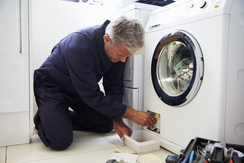 Technician Repair the Drain Filter of a White Front-load Washing Machine — Eurocoast Appliance Service In Morisset, NSW