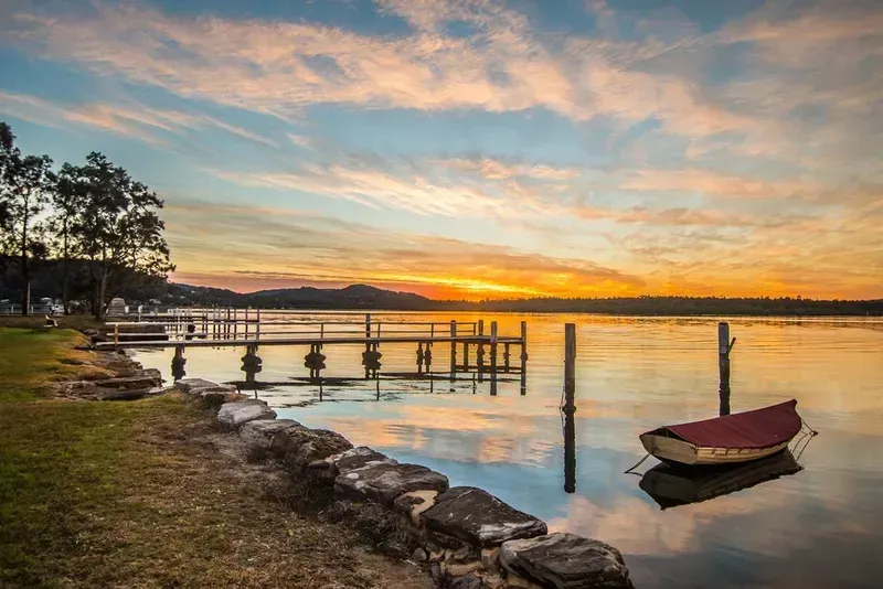 Serene Sunset Over a Calm Lake With a Wooden Pier — Eurocoast Appliance Service In Woy Woy, NSW