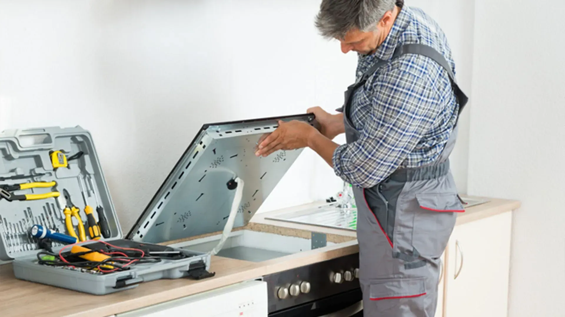 Technician Repairs a Kitchen Stovetop — Eurocoast Appliance Service In Bateau Bay, NSW