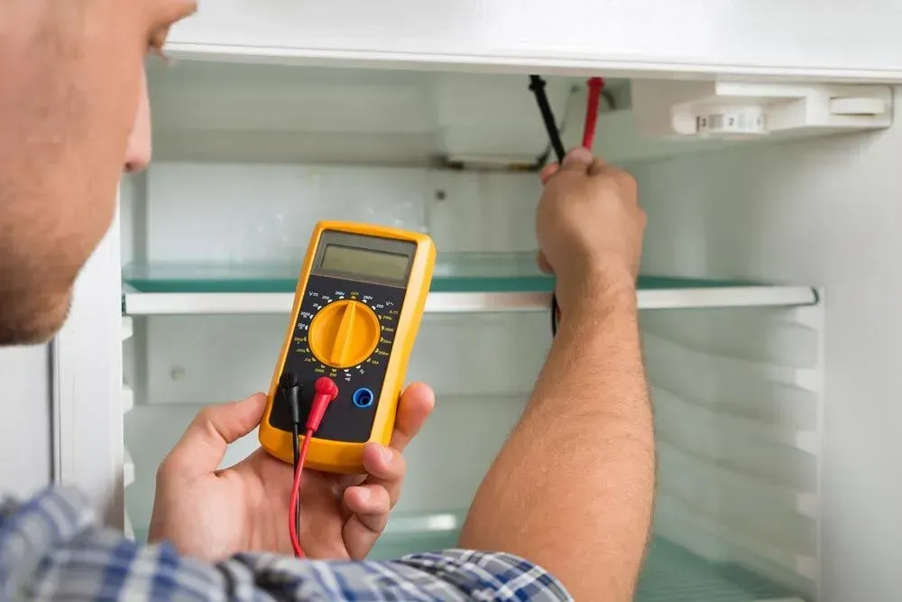 Person Using a Yellow Digital Multimeter — Eurocoast Appliance Service In Tuggerah, NSW