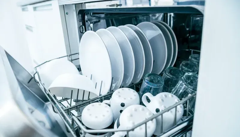 Open Dishwasher Rack Filled With Clean White Plates — Eurocoast Appliance Service In Tuggerah, NSW