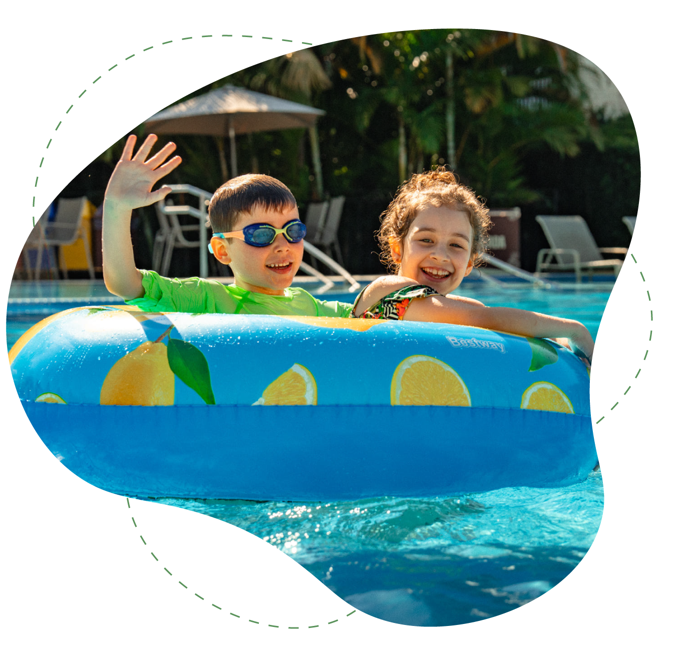 Criança usando óculos de natação vermelhos e azuis, sorrindo na água contra um fundo de piscina brilhante.