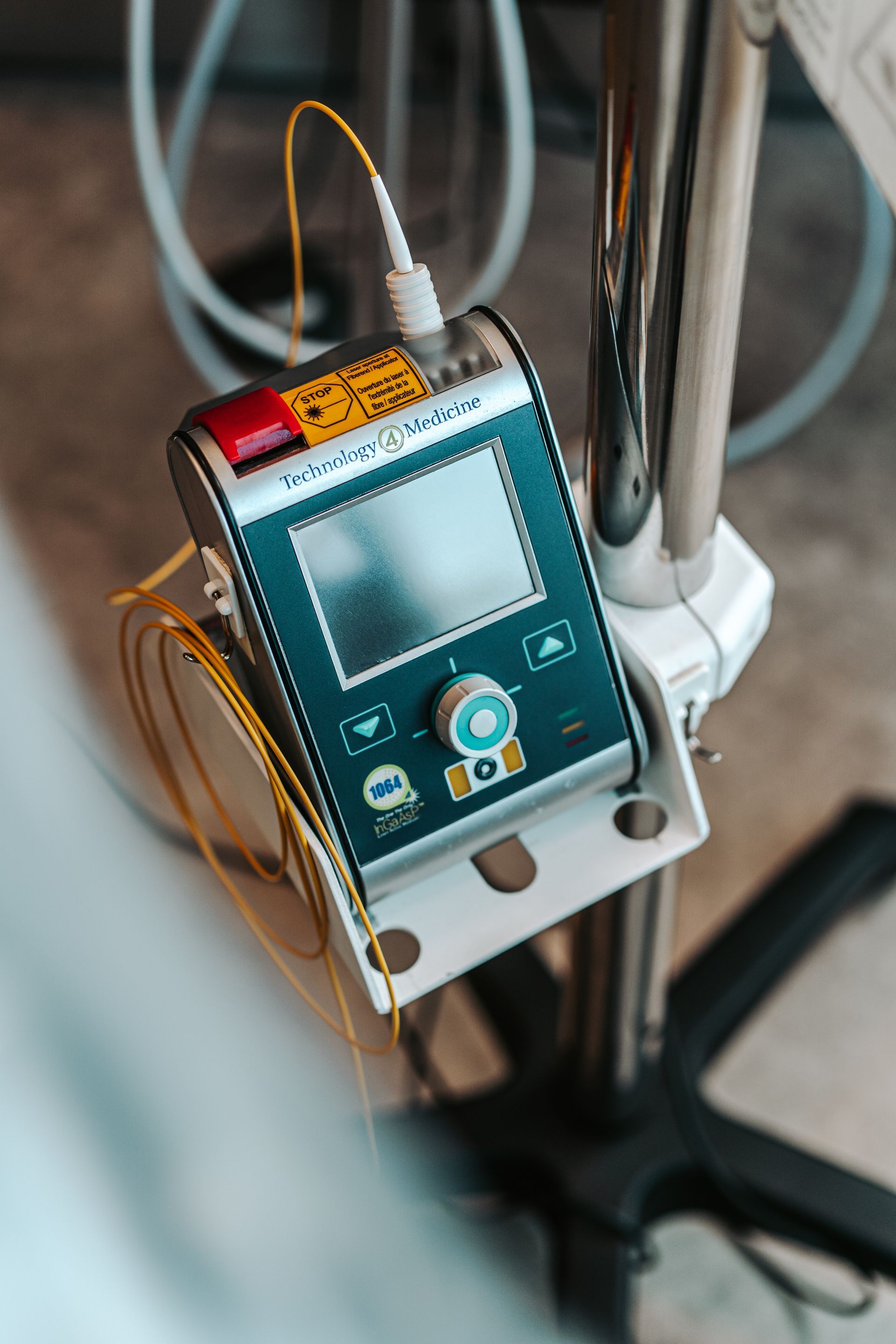 A portable FOX laser device with an attached fiber optic cable and a sterile applicator on a speckled countertop.