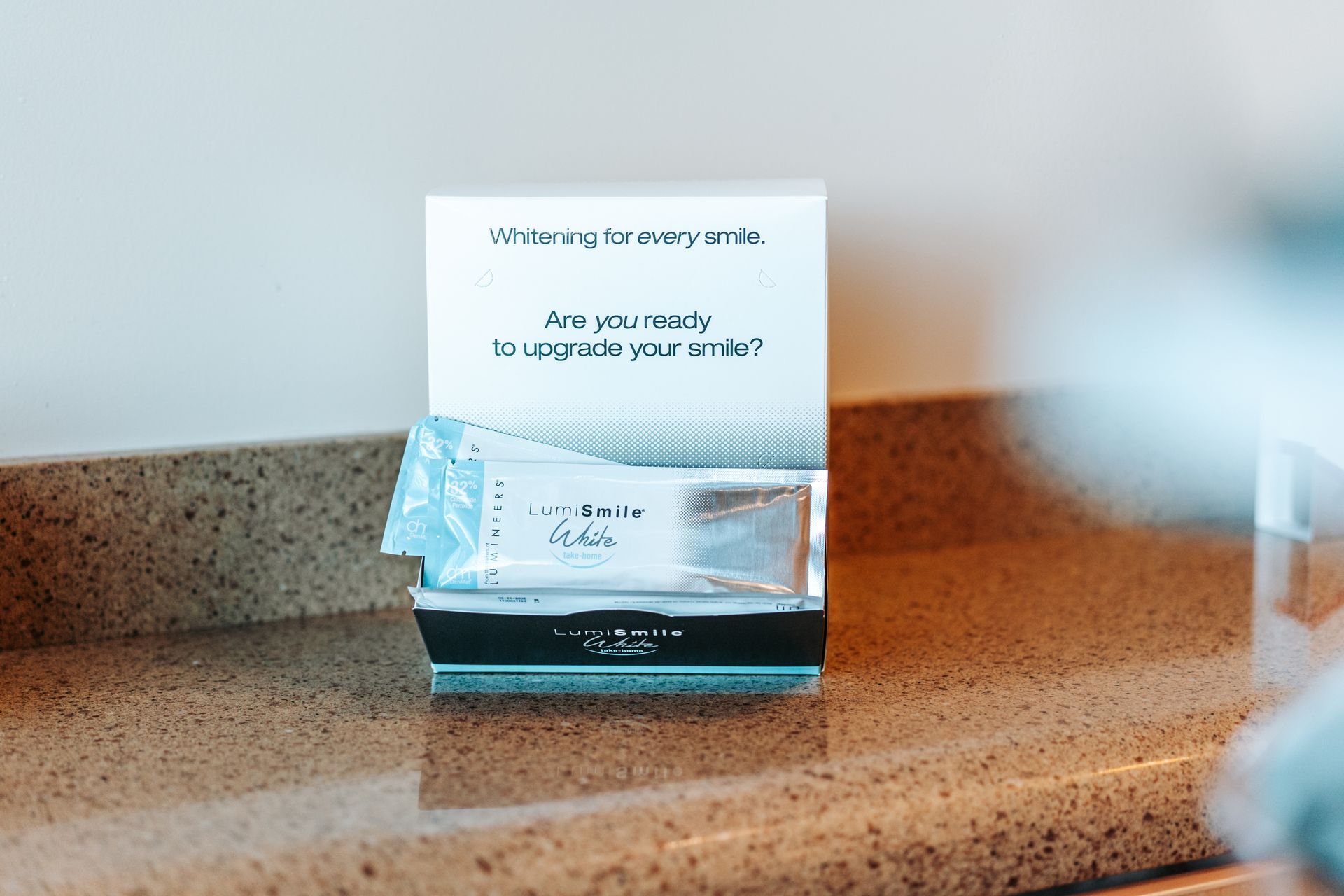 Box with teeth whitening strips on a countertop. Text: