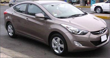 Sedán Hyundai marrón estacionado en una calle, vista frontal izquierda.