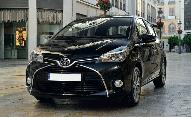 Un Toyota hatchback negro estacionado en una calle de la ciudad.