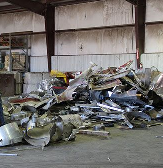Pile of crushed metal debris in an industrial warehouse bay