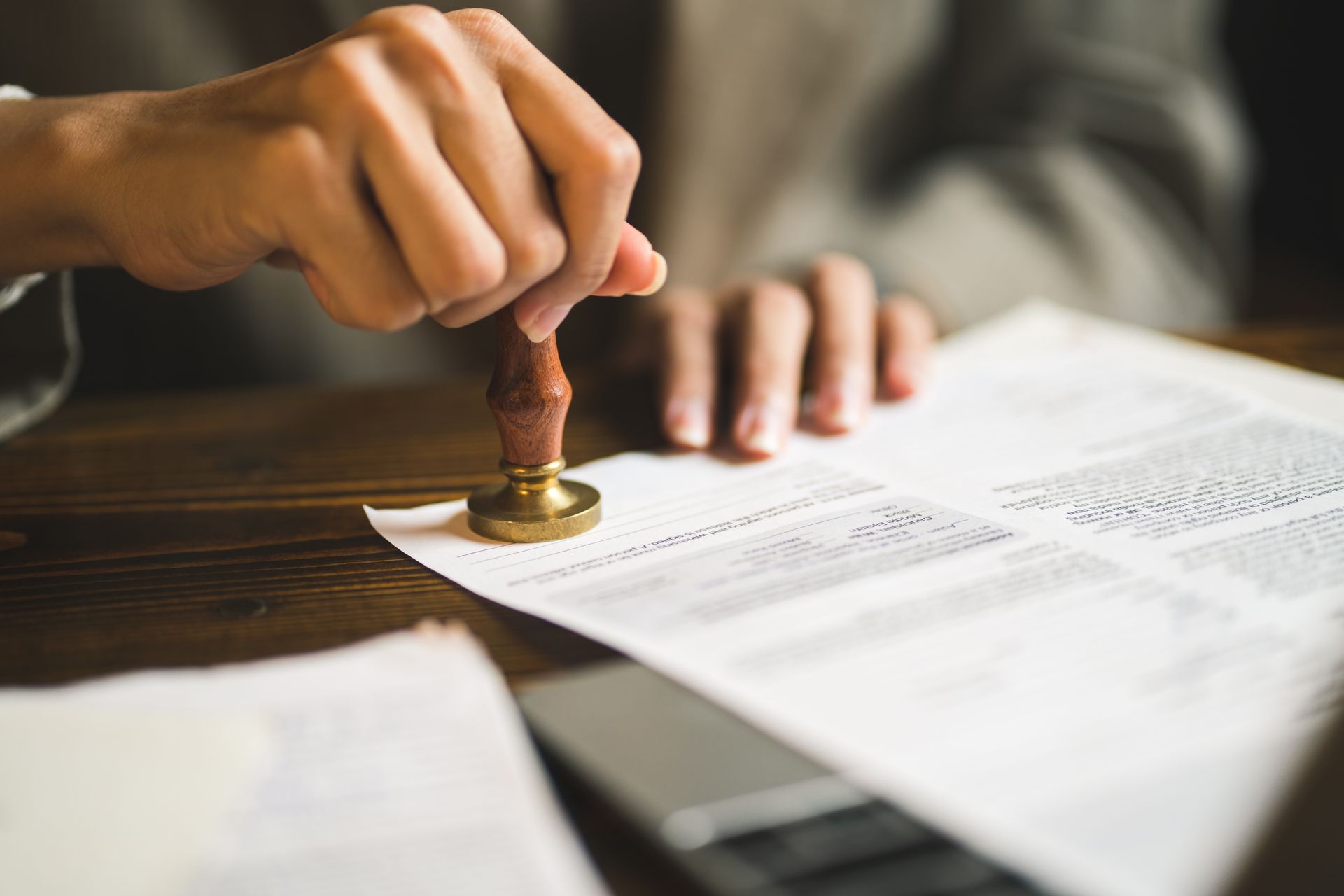Hand stamping a document on a wooden desk