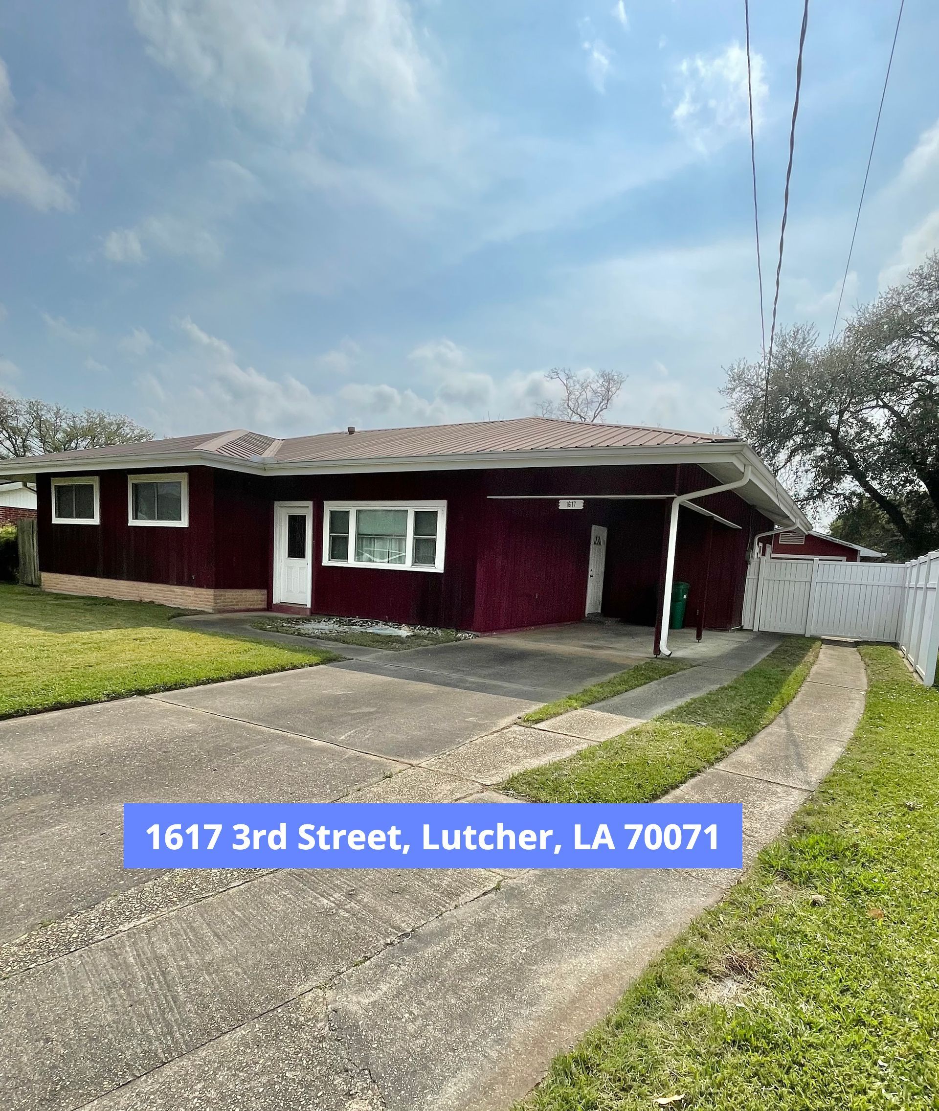 Single-story maroon house with white trim and driveway at 1617 3rd Street, Lutcher, LA 70071