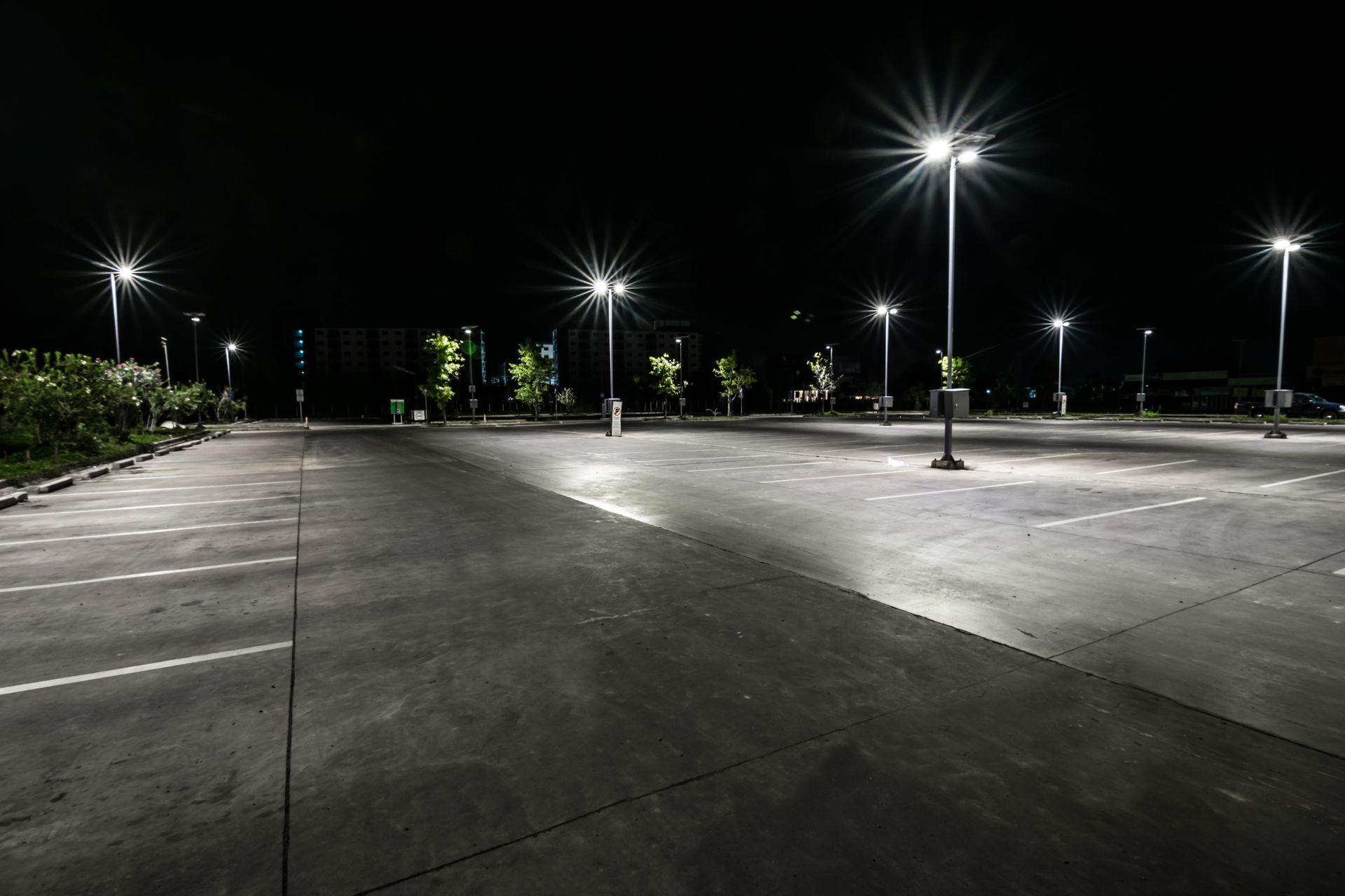 An empty parking lot is lit up at night.