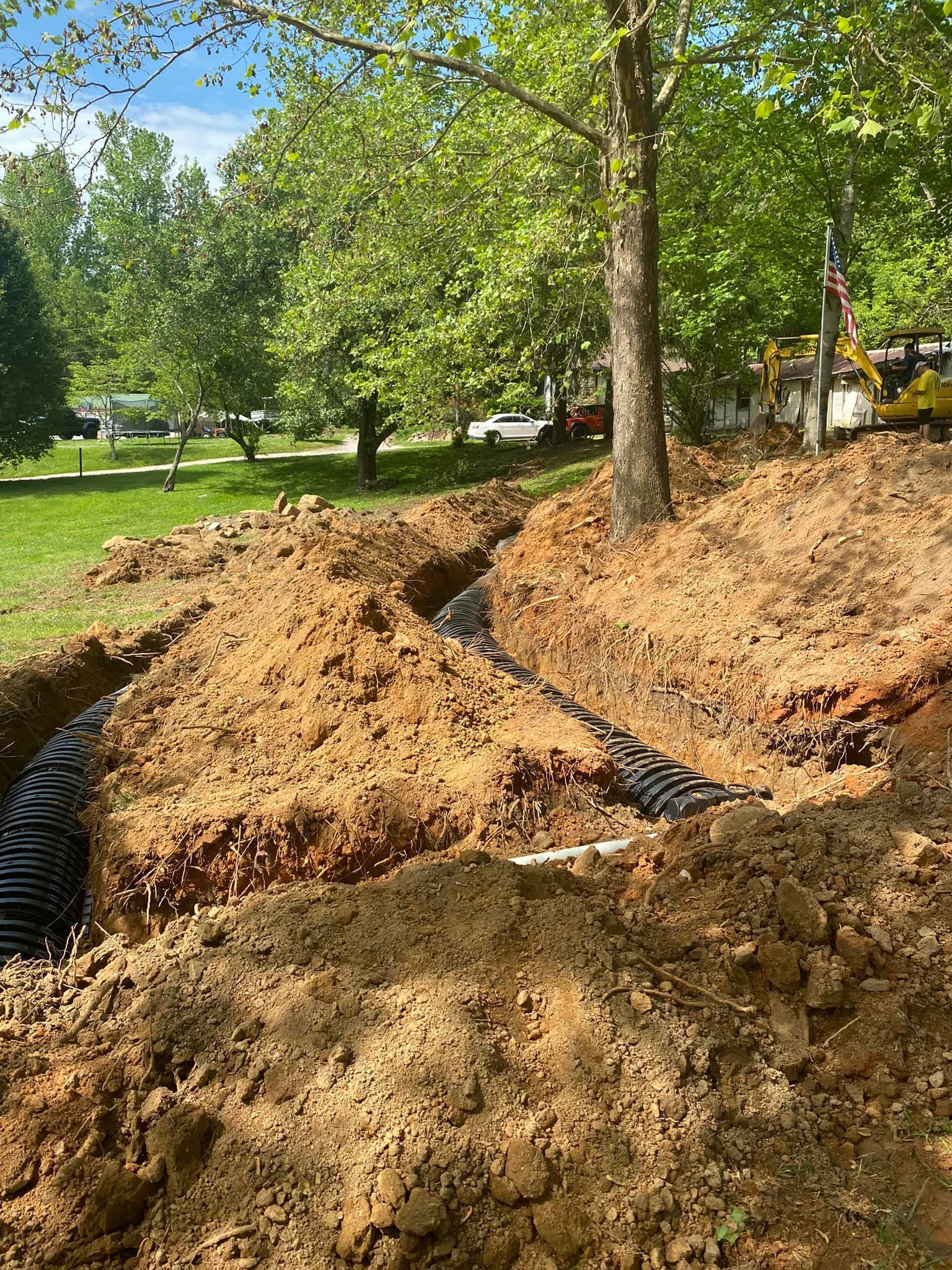 A large pile of dirt is being dug up in a park.