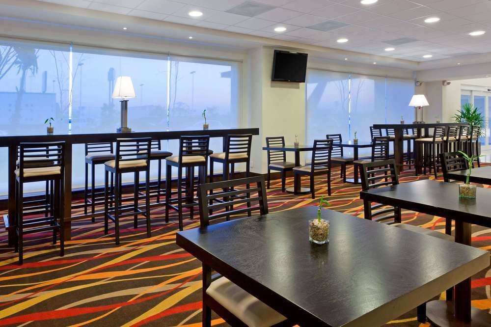 Un restaurante con mesas y sillas y un televisor en la pared.