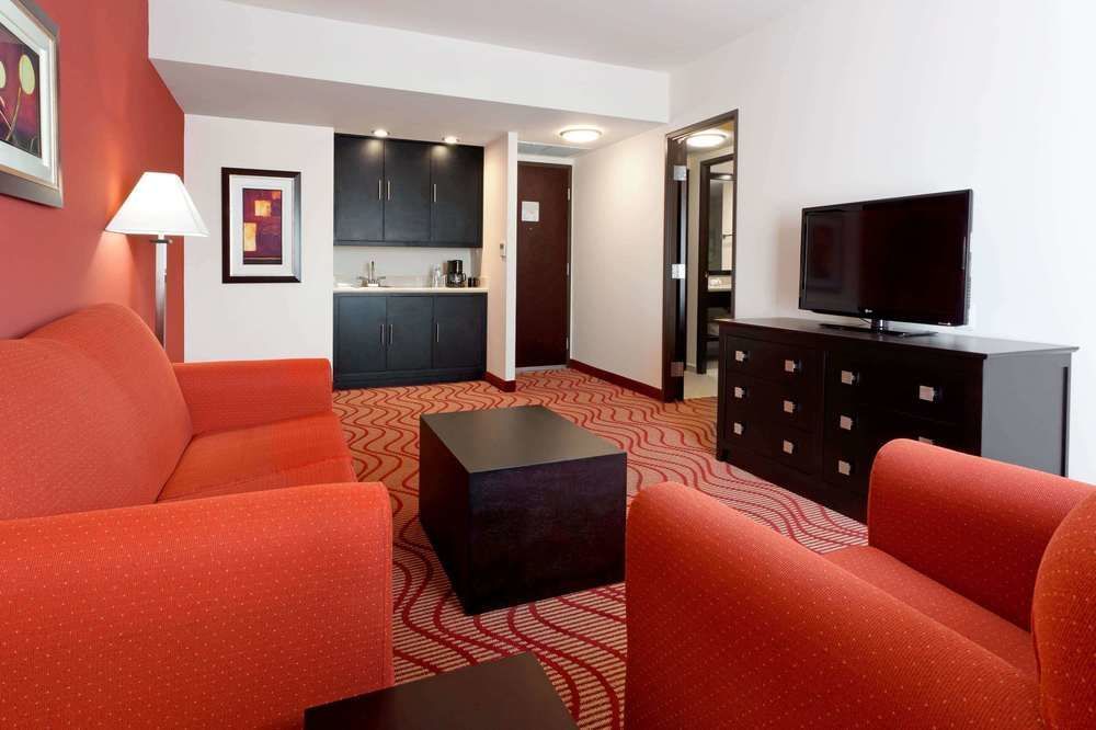 Una sala de estar con muebles rojos y un televisor de pantalla plana.