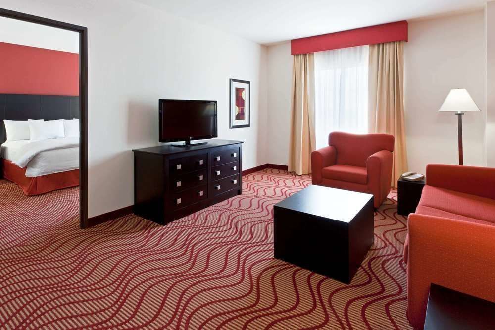 Una habitación de hotel con un sofá, una silla y un televisor.