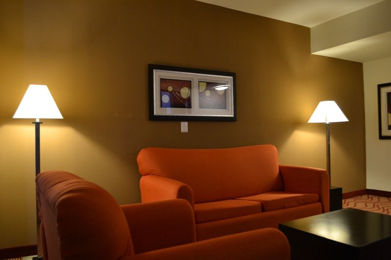 Una sala de estar con un sofá naranja y dos lámparas.