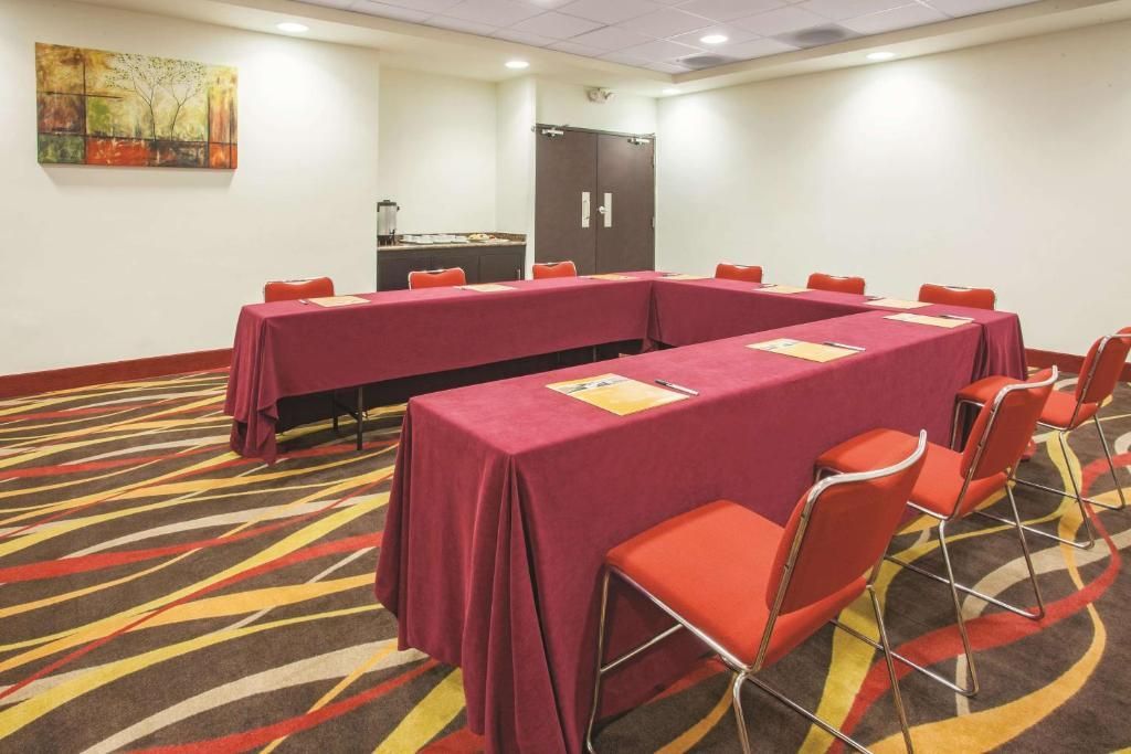 Una sala de conferencias con mesas y sillas preparadas para una reunión.