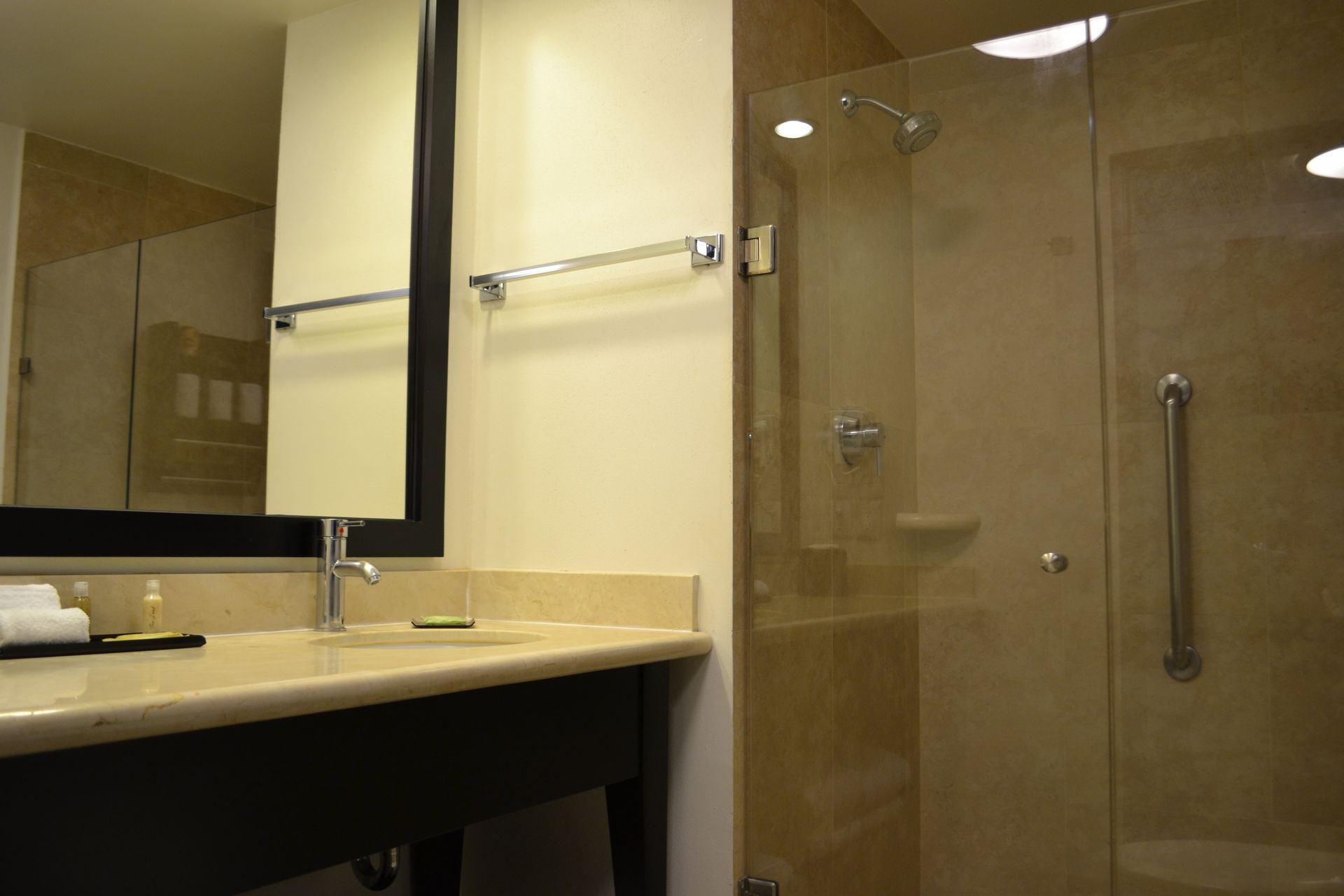 Un baño con lavabo y ducha con puerta de cristal.