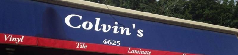Blue storefront sign reading “Colvin’s” with smaller text for vinyl, tile, and laminate.