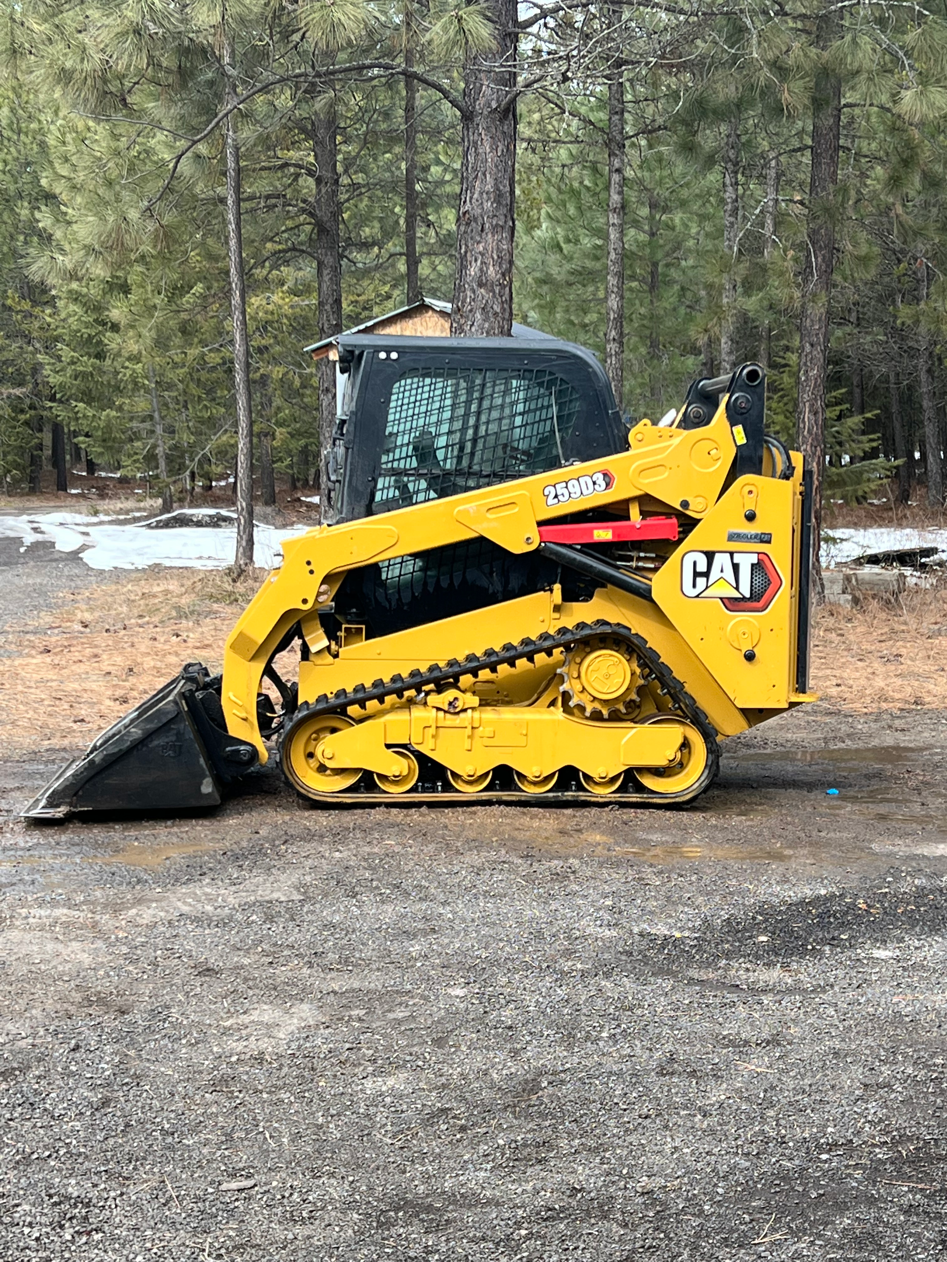 A yellow bulldozer is digging a hole in a yard.