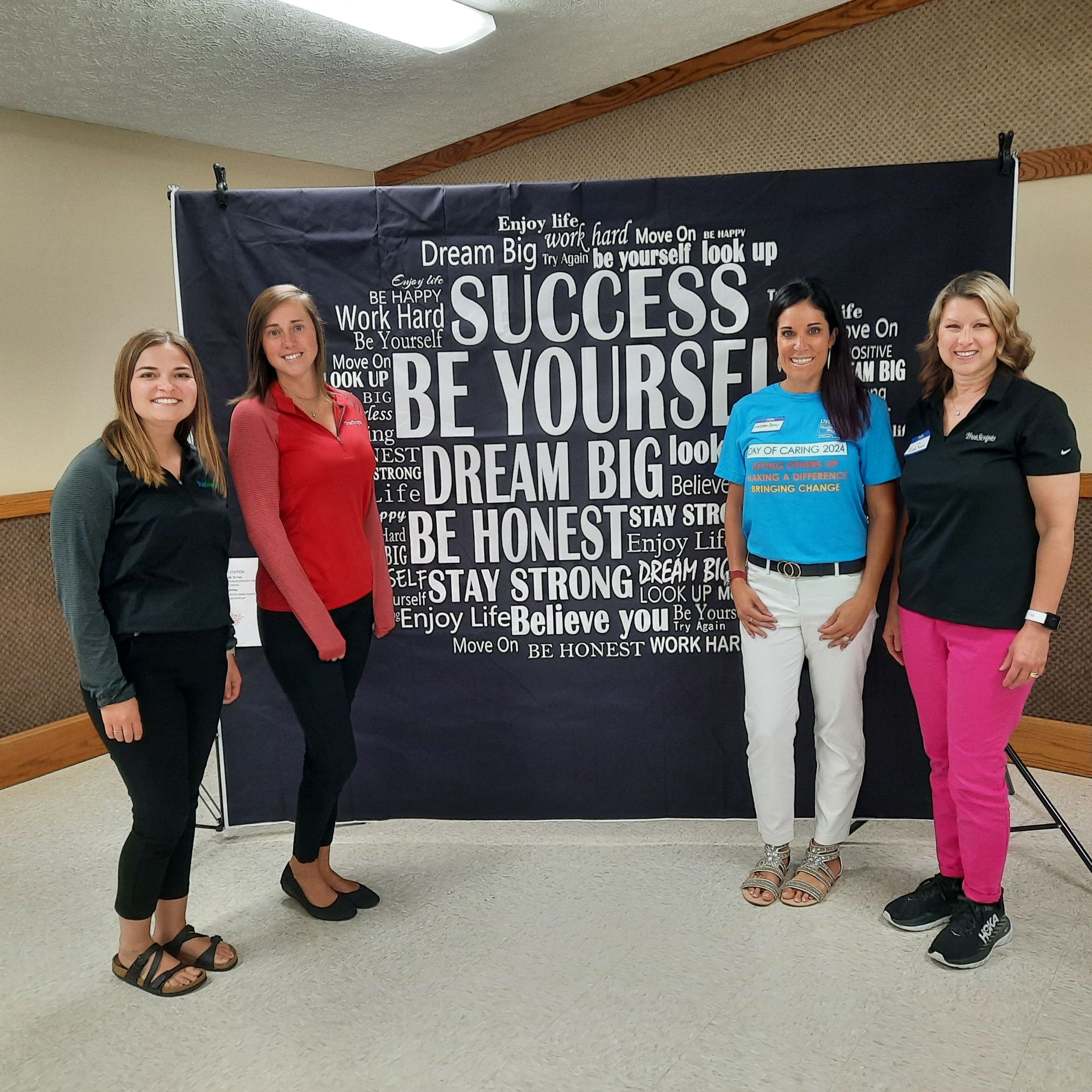 Four female TrueScripts employees smiling at a volunteer event