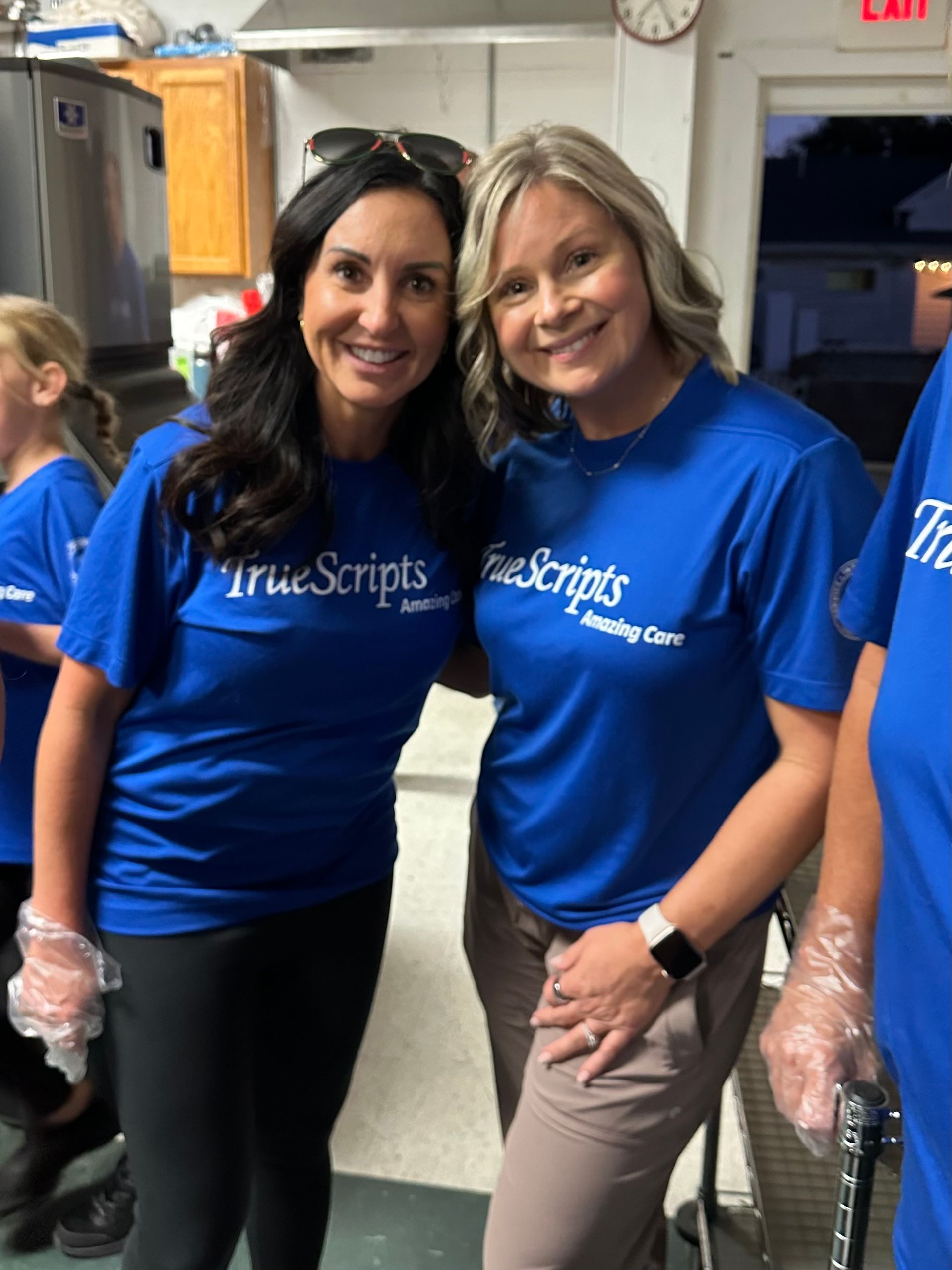 Two TrueScripts employees posing together smiling at a volunteer event