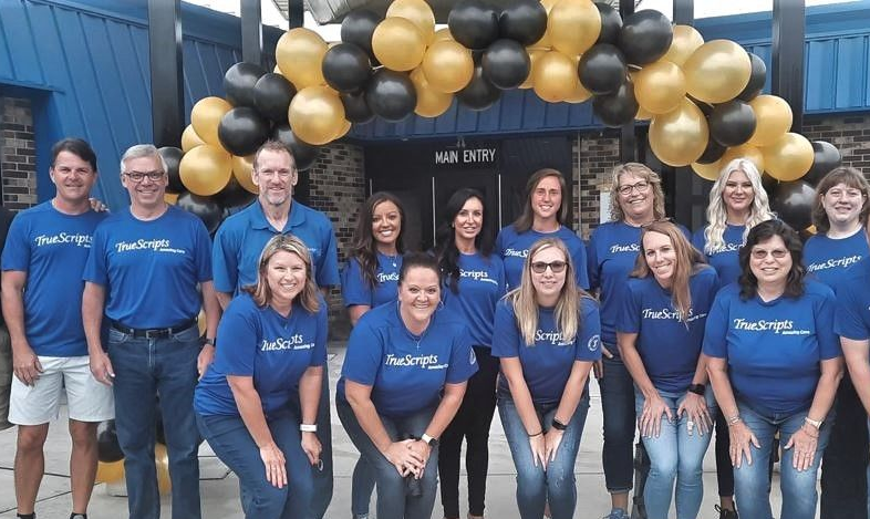 Group of TrueScripts employees posing together smiling at a volunteer event