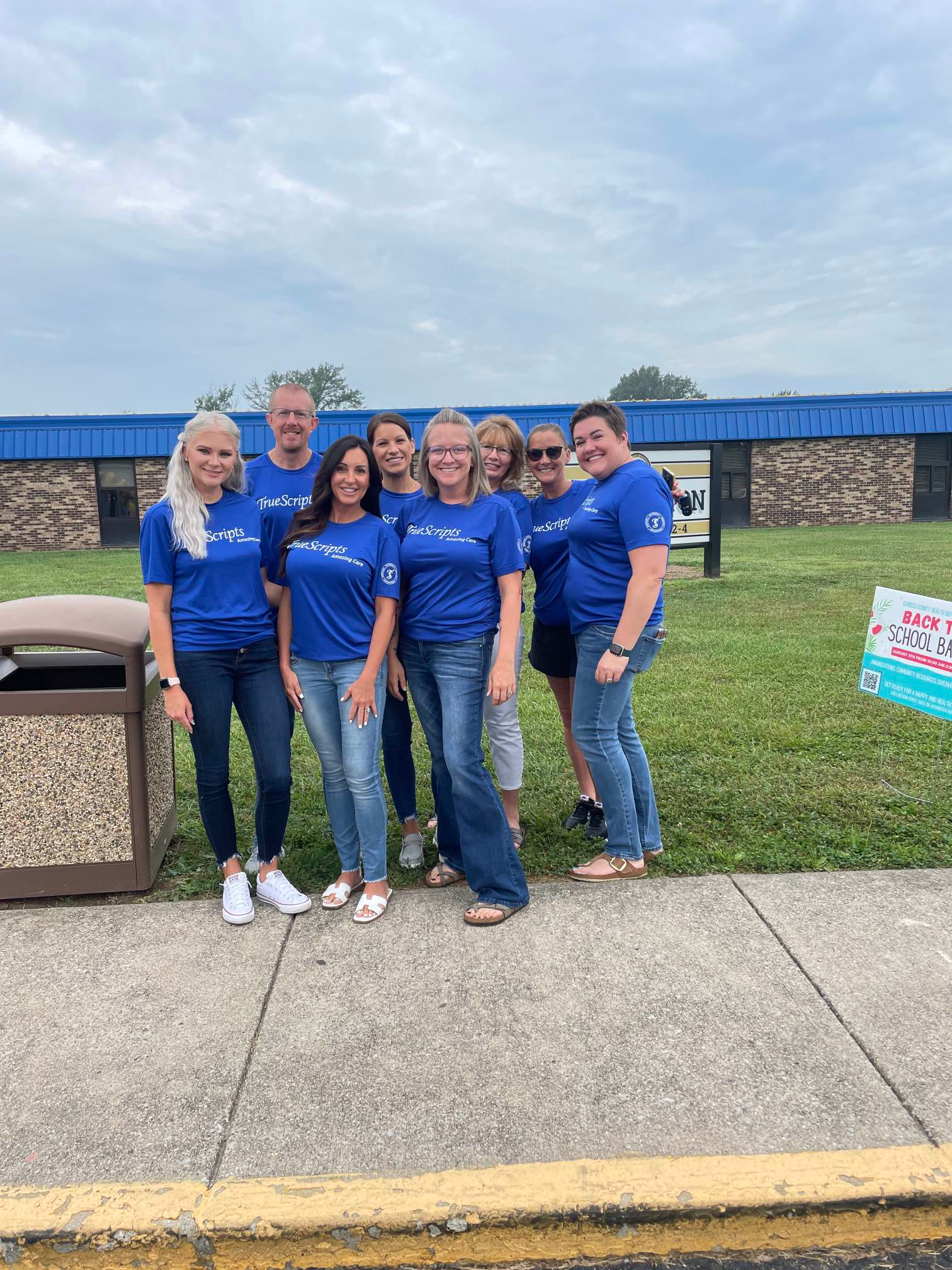 Group of TrueScripts employees posing together smiling at a volunteer event