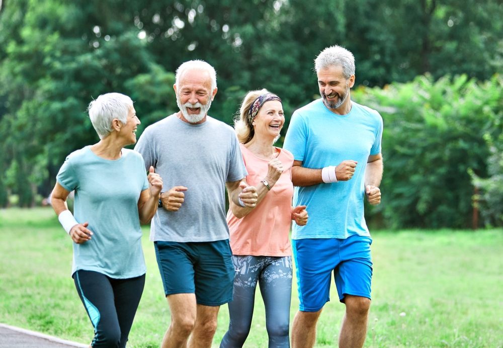 A group of elderly people are jogging in a park.