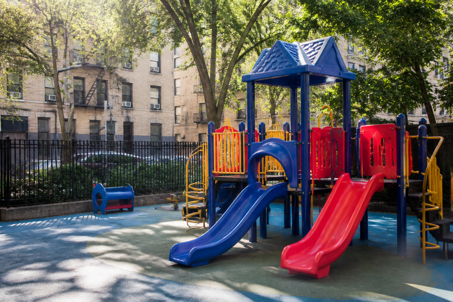 Empty museum steps and a fenced city playground on a quiet Manhattan block, illustrating NYC daycare
