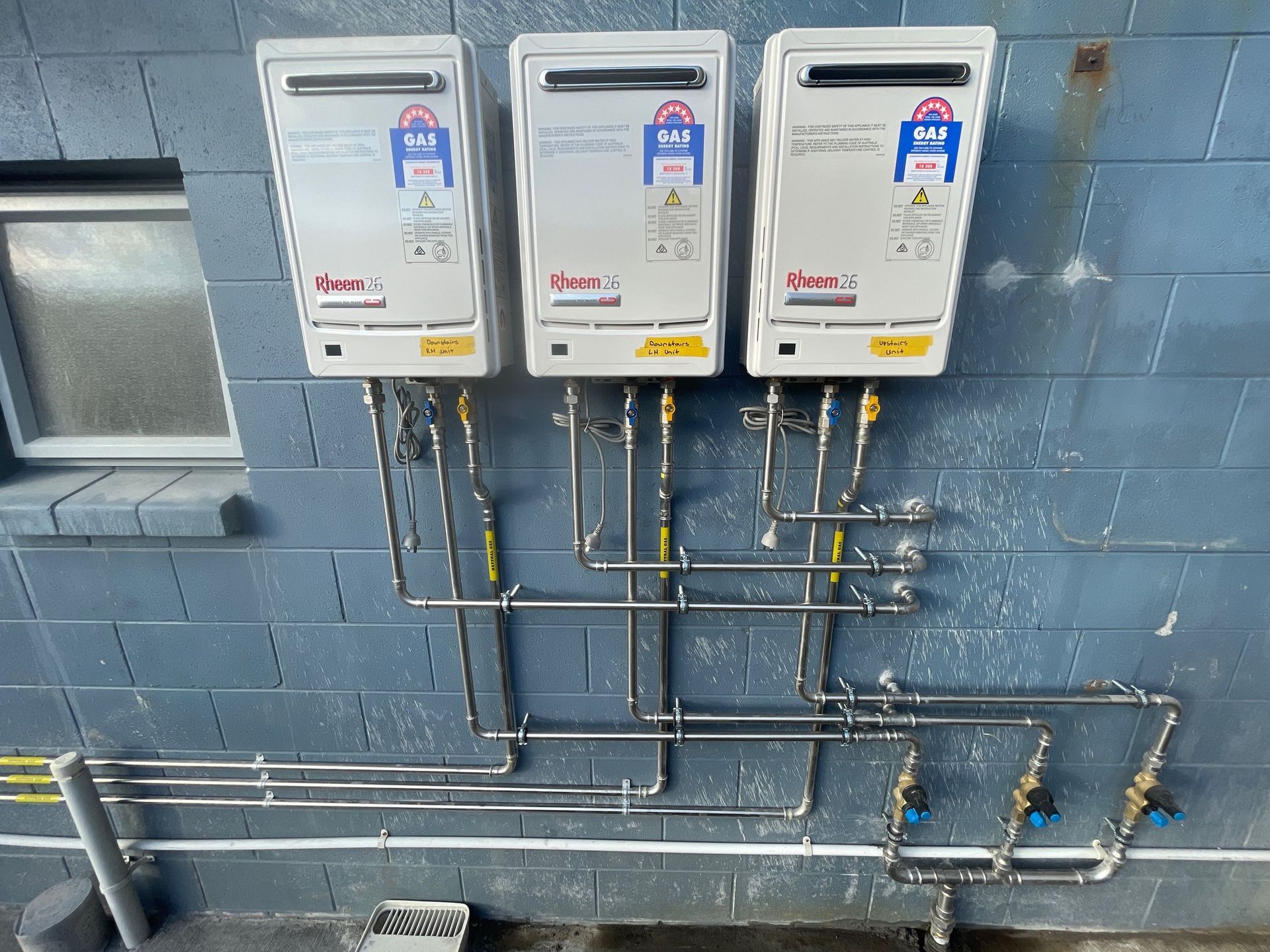 A bunch of pipes are connected to a brick wall