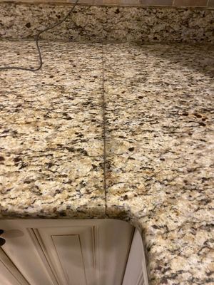 Speckled granite kitchen countertop with a cabinet edge visible below