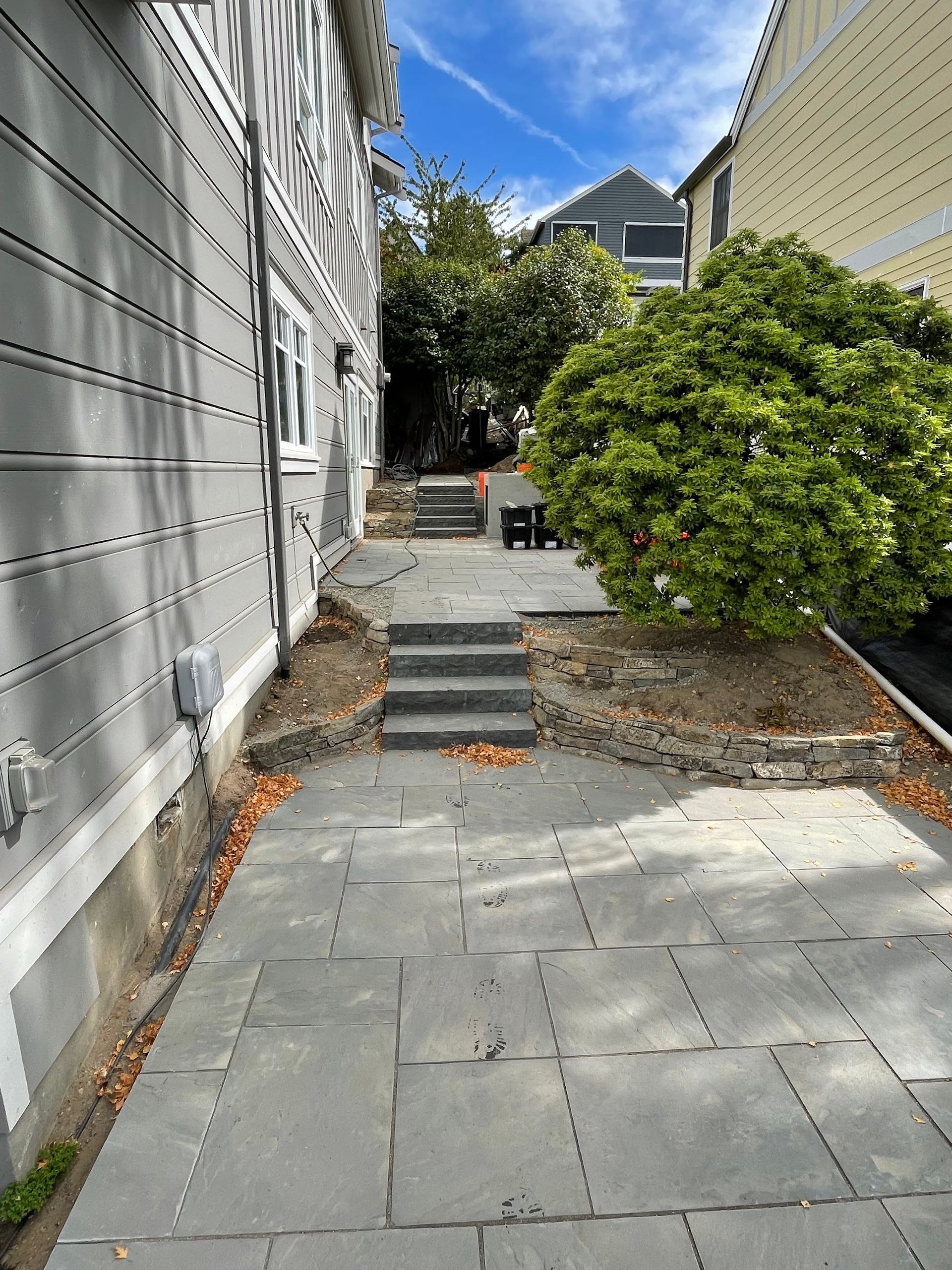 A sidewalk leading to a house with stairs leading up to it.