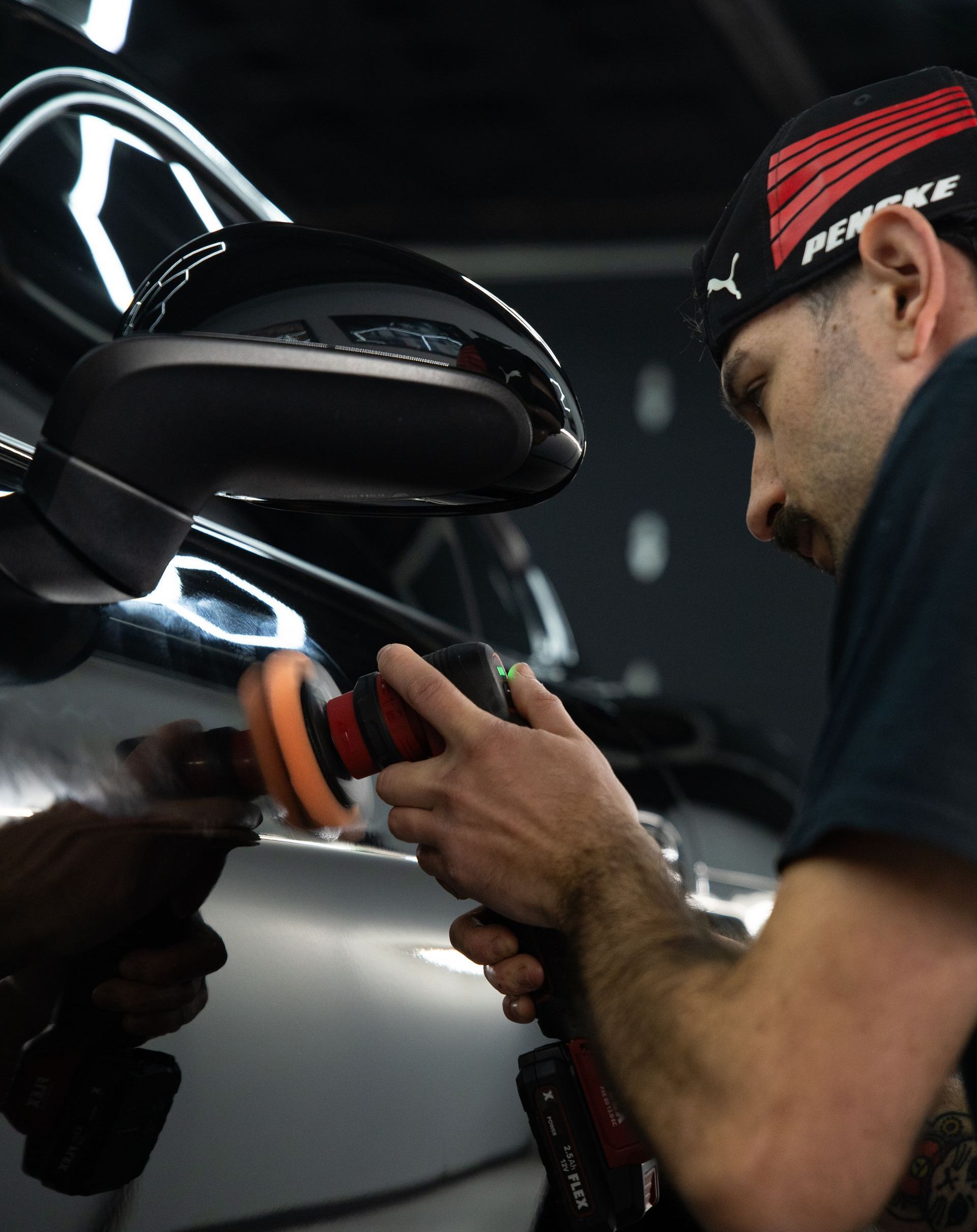 A man is polishing a car with a polisher.