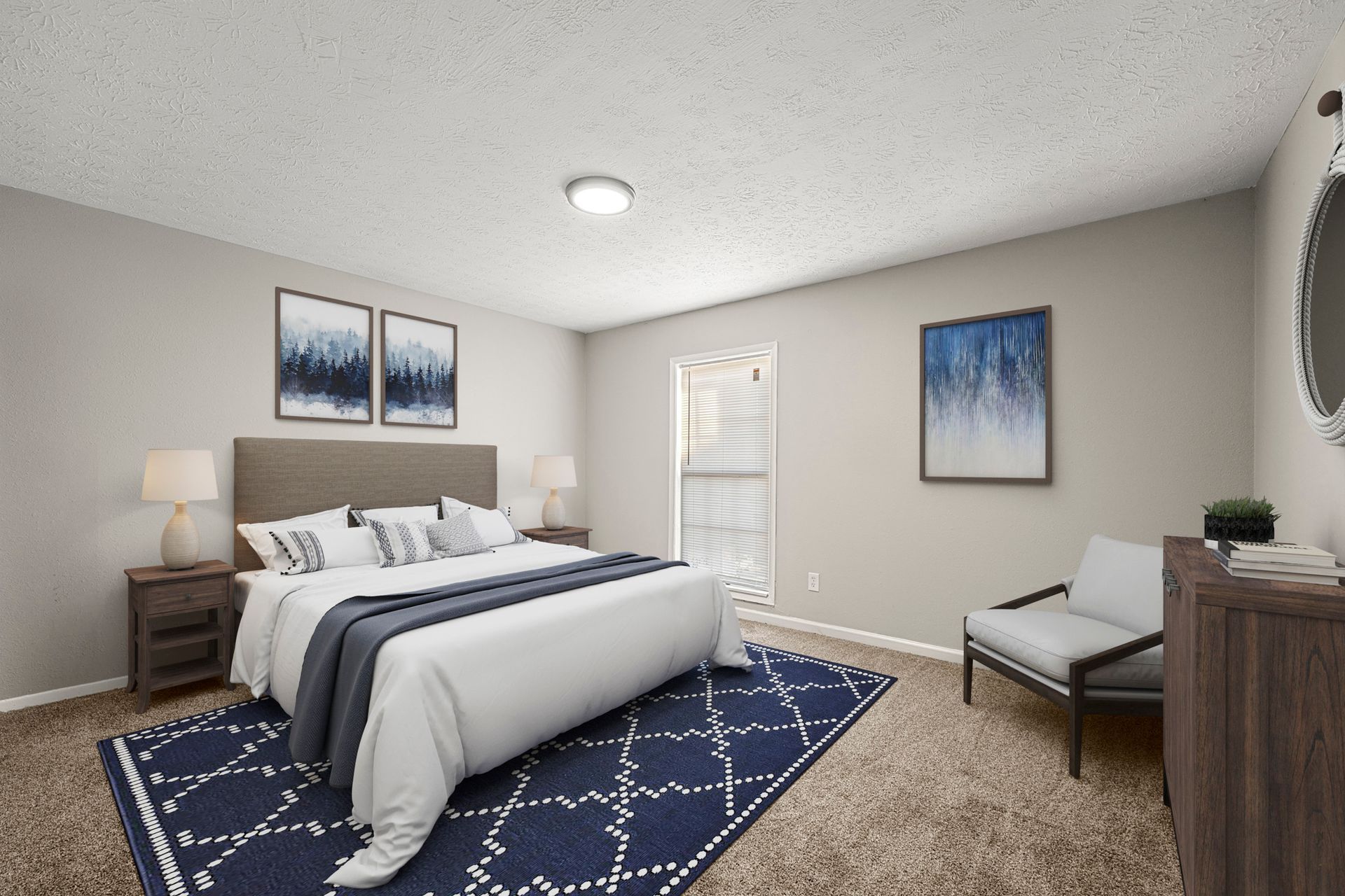 Bright modern bedroom with white bed, blue rug, nightstands, chair, and framed wall art