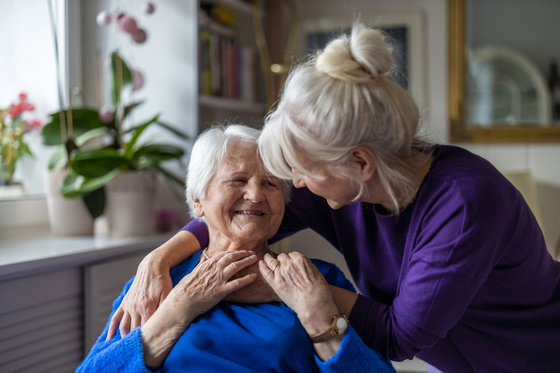 A woman is hugging an elderly woman in a living room – Minden, NE - Bethany Home