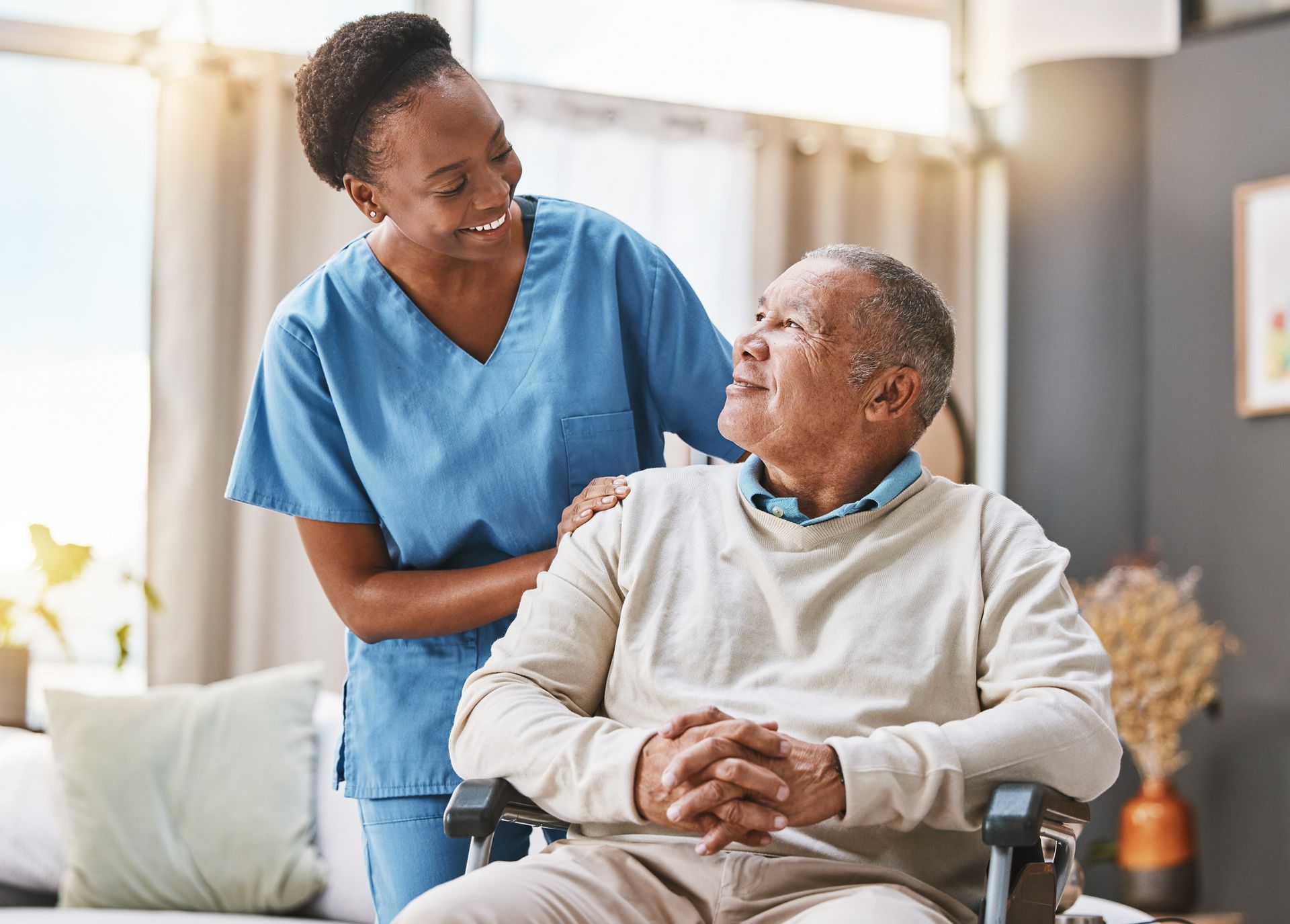 A nurse is standing next to an elderly man in a wheelchair – Minden, NE - Bethany Home