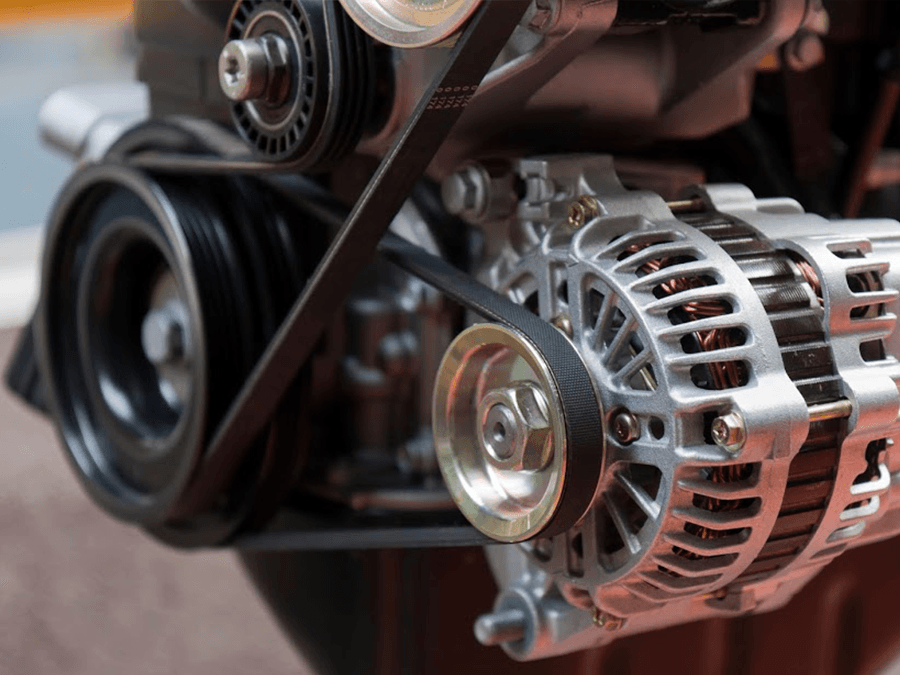 A close up of a car engine with a belt attached to it.