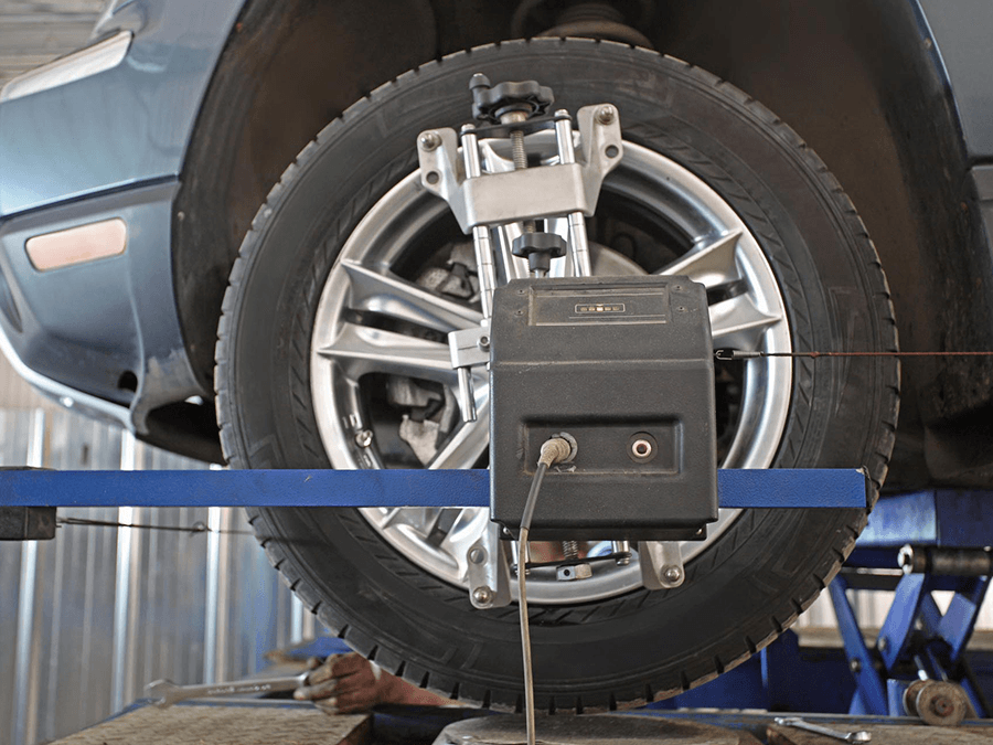 A car is being aligned with a machine in a garage.