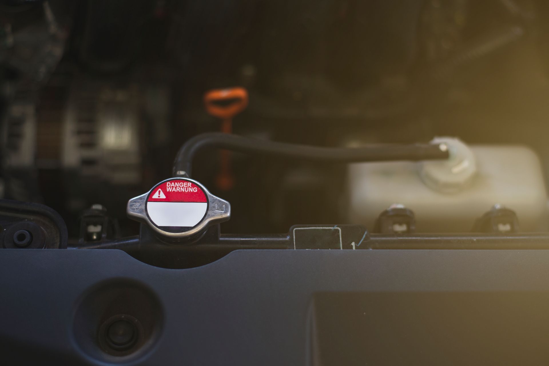 A close up of a radiator cap on the hood of a car.